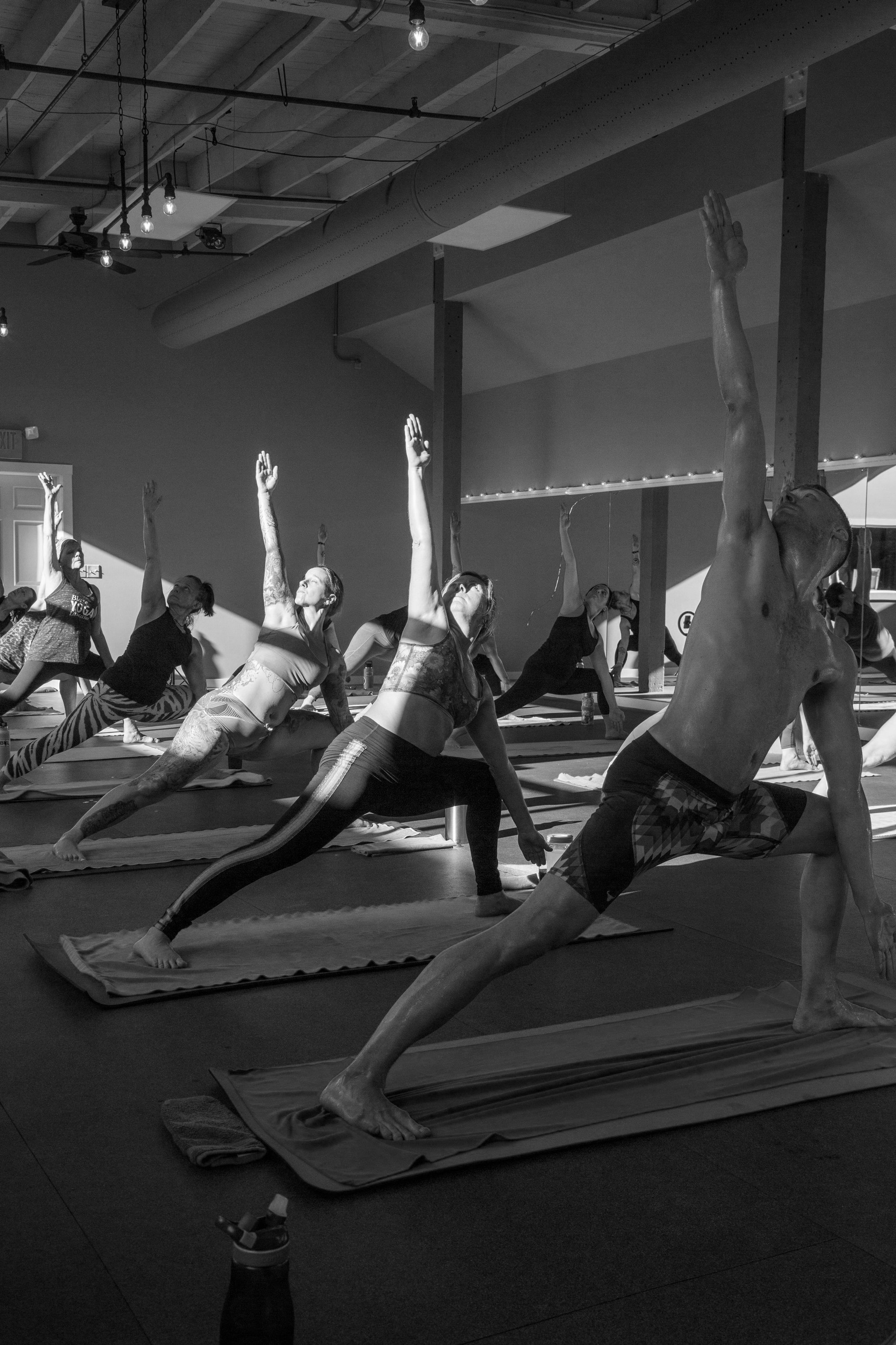 Student holding a long, supported standing stretch in soft studio light